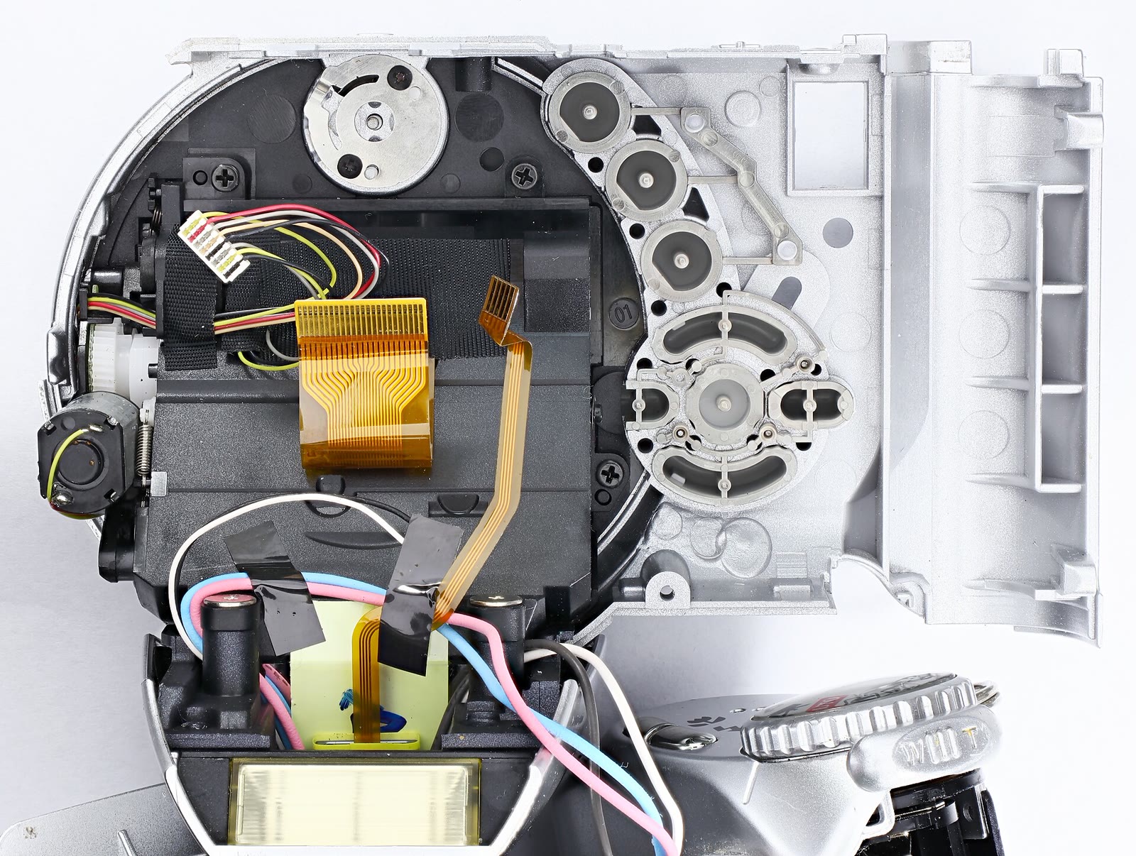 Disassembled Minolta camera rear assembly showing the LCD ribbon cable and separate wiring