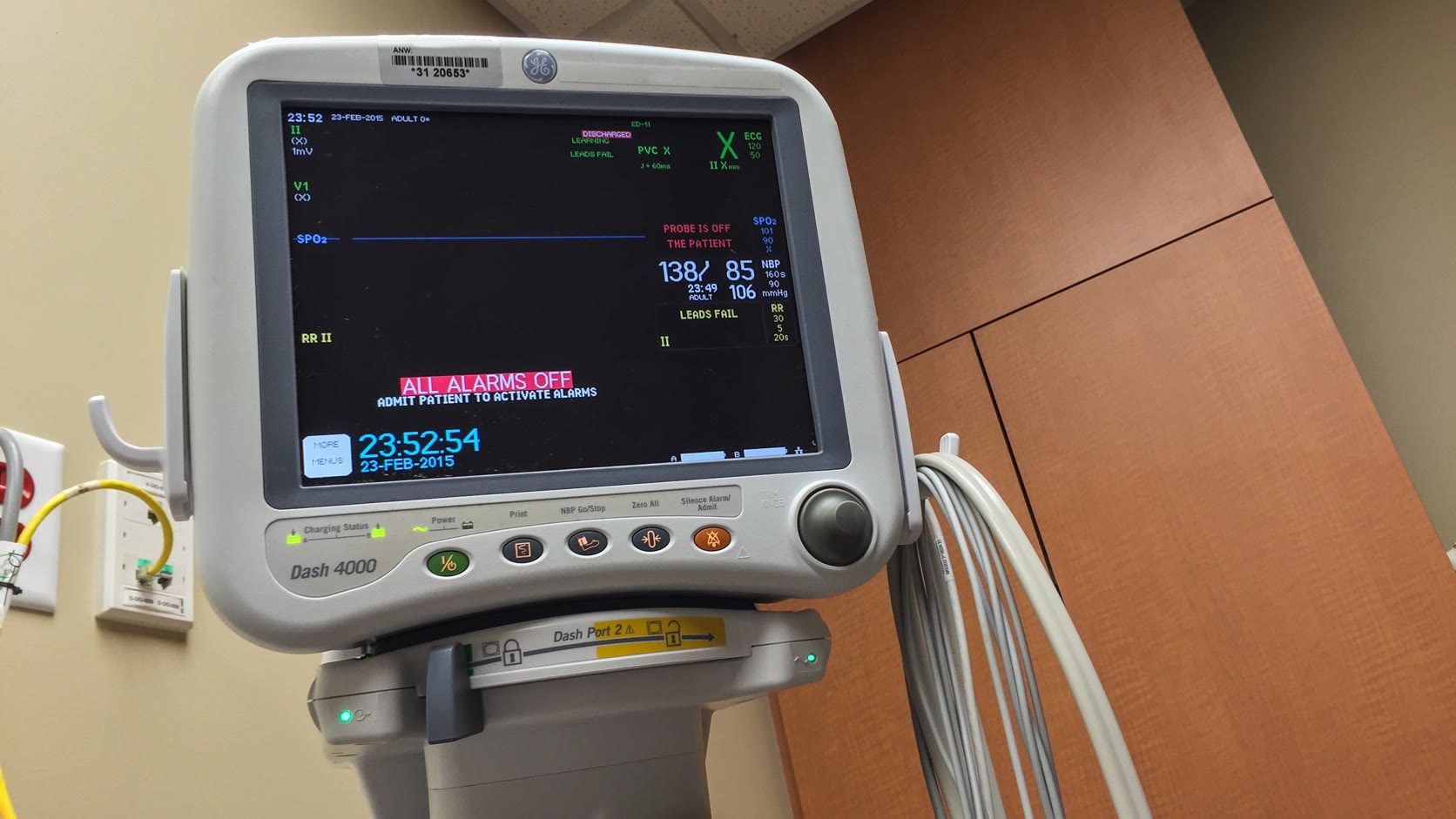 Real bedside patient monitor showing physiological values, status messages, alarms, and physical controls